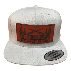 Gray flatbill snapback with a leather fis patch with two shotguns and trees